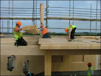 Workers fit timber floor panels on the building’s 3rd floor 