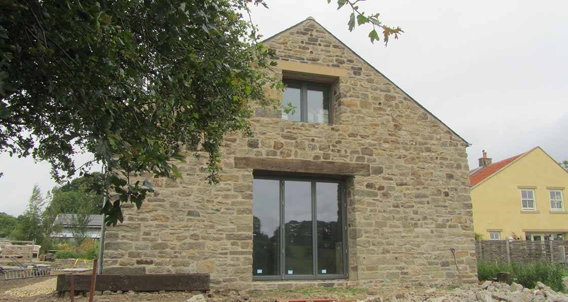 Barn retrofit achieves 0.18 ACH with bi-fold doors